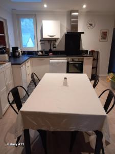 uma cozinha com uma mesa branca com cadeiras em L'auseth em Oloron-Sainte-Marie