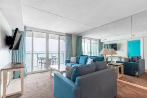 een woonkamer met een blauwe bank en een televisie bij Bay Club Resort in Ocean City