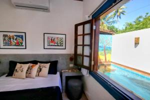 a bedroom with a view of a swimming pool at Milagres de Minas in São Miguel dos Milagres