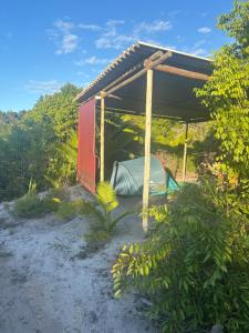 un capanno rosso con una tenda sotto. di Corumbau cura - Camping a Corumbau