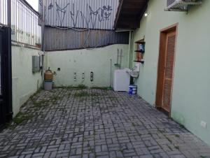 an empty courtyard with a wall with writing on it at Casa Vila da Saúde, aconchegante com 2 garagens e 2 quartos in São Paulo