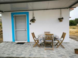 Livadi apt في Paránimfoi: طاولة وكراسي على فناء