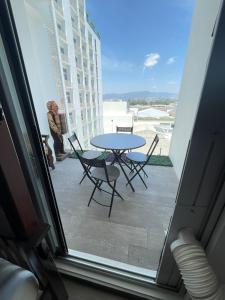 a person sitting on a balcony with a table and chairs at Narama Luxury near to the airport in Guatemala