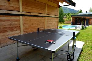 a ping pong table in a backyard with a pool at Chalet neuf avec piscine privée et Jacuzzi, proche Paradiski in Aime-La Plagne