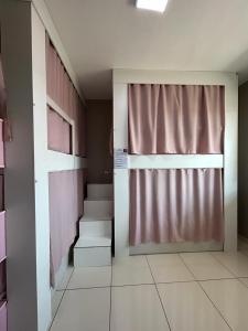 um quarto vazio com escadas e uma cortina e um quarto com em Elô Hostel em Brasília