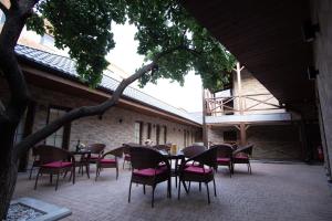 a patio with tables and chairs and a tree at BLH in Yerevan