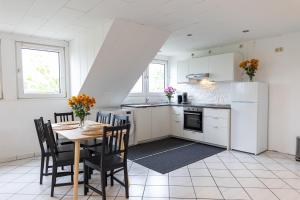 a kitchen and dining room with a table and chairs at Staufenberg in Korschenbroich