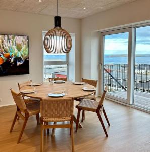 a dining room with a table and chairs and a large window at Faroe Stay Apartments, No.5 in Tórshavn