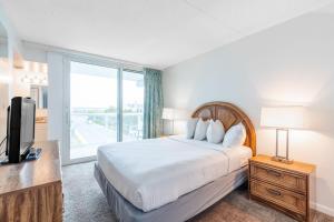 1 dormitorio con 1 cama, TV y ventana en Bay Club Resort, en Ocean City