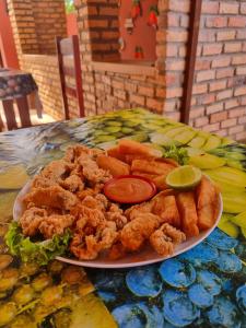 a plate of food on a table with chicken and vegetables at Pousada Brasil - São Miguel do Gostoso in São Miguel do Gostoso