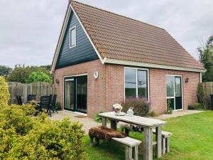 a house with a picnic table in the yard at Vrij uitzicht Texel in De Koog