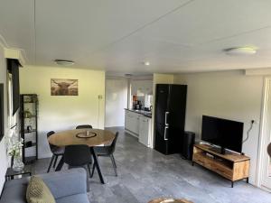 a living room with a table and a kitchen at Casa Mooi Zeegse in Zeegse