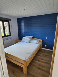 にあるMaison bois de 65m²の青い壁のドミトリールームのベッド1台分です。