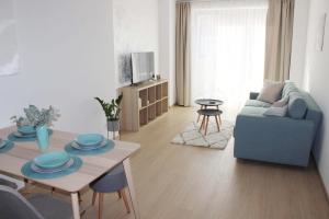 a living room with a table and a blue couch at Apartmán POD ROTUNDOU in Skalica