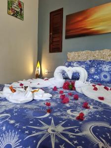 a bed with red flowers laying on it at Pousada Brasil - São Miguel do Gostoso in São Miguel do Gostoso