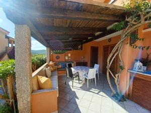 een patio met een tafel en stoelen op een huis bij CASA SIBILLA bi-locale con terrazza a 60 metri dal mare in Marinella