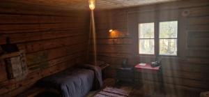 Lapland Old School في مونيو: غرفة بها سرير ونافذة في كابينة خشب