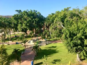 un parque con césped verde y árboles en un día soleado en Marina Park Plaza Q, en Santa Cruz Huatulco