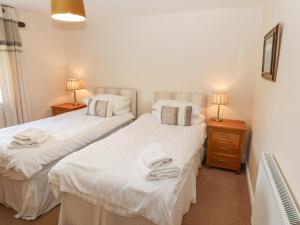 2 łóżka pojedyncze w pokoju z 2 lampami w obiekcie Goswick Hall w mieście Bowland Bridge