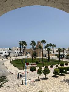 a view of a park with palm trees and a street at Charmant Bungalow avec Vue Panoramique sur le Port de Kantaoui à Sousse in Sousse