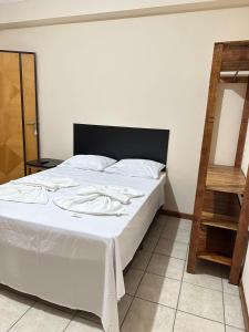 a bedroom with a white bed with a wooden ladder at Hotel Central Plaza Timóteo in Timóteo +29 photos