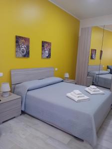 a bedroom with two beds and a yellow wall at Casa Pandora RosaApartmentsOrtigia in Siracusa