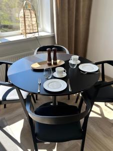 una mesa negra con platos y vasos. en Liiva Paasukese Apartment en Liiva