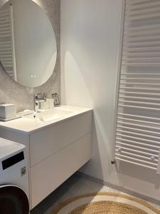 a white bathroom with a sink and a mirror at Liiva Paasukese Apartment in Liiva +12 photos