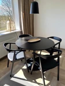 una mesa negra y sillas en una habitación con ventana en Liiva Paasukese Apartment en Liiva