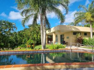 uma casa com piscina e palmeiras em Black Rock Villas em Rarotonga