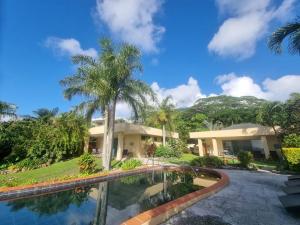 dom z basenem przed nim w obiekcie Black Rock Villas w mieście Rarotonga