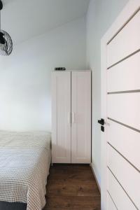 Nemirseta في بالانغا: غرفة نوم بدولاب أبيض وسرير