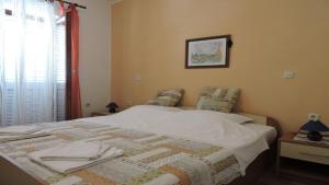 een slaapkamer met een bed met een quilt bij Apartments Ivanov in Novalja