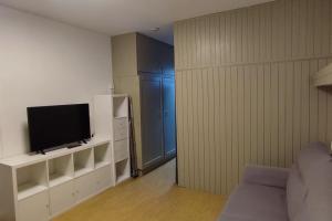 a living room with a tv on a white entertainment center at Studio 4 Personnes côté Sud in Superdevoluy