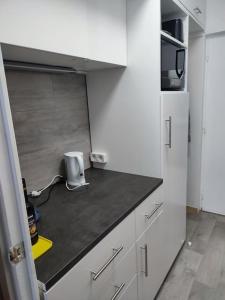 Una cocina con gabinetes blancos y encimera. en Studio 4 Personnes côté Sud, en Superdevoluy 1 foto más