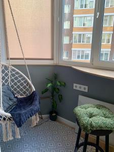 a room with a swing and a chair and a plant at Comfort Home Soborna 283 in Rivne