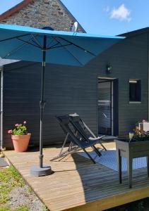 un parasol bleu et une chaise sur une terrasse en bois dans l'établissement Studio de charme indépendant avec terrasse, à Les Chéris