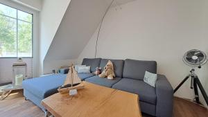 a living room with a blue couch and a table at Meerblick-Ferienwohnung im Cottage Rerik in Neu Gaarz