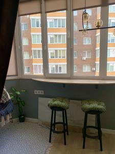 a room with two stools in front of a window at Comfort Home Soborna 283 in Rivne