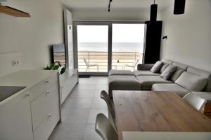 salon z kanapą i stołem w obiekcie Ostend Sea View Apartment w Ostendzie