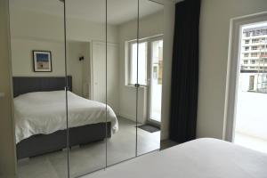 sypialnia z łóżkiem i lustrem w obiekcie Ostend Sea View Apartment w Ostendzie