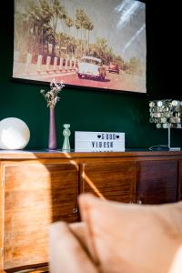 een houten dressoir met een foto op een groene muur bij The Good Vibes Honfleur & pkg included in Honfleur