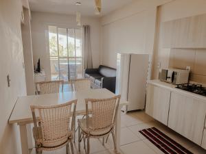 a kitchen and living room with a table and chairs at Kitecabana Apartamento in Caucaia