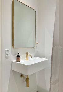 a bathroom with a white sink and a mirror at JANTZENs HOTEL in Gudhjem