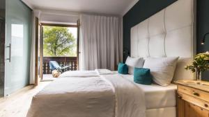 a bedroom with a large white bed and a window at Pension Sonnheim in Gargazzone