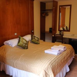 Una habitación de hotel con una cama con toallas. en Valle Frío Ushuaia en Ushuaia