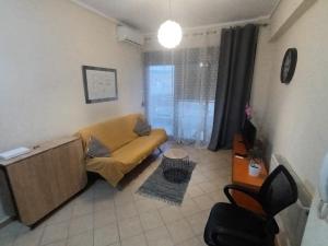 sala de estar con sofá y ventana en Sunny penthouse, en Tesalónica