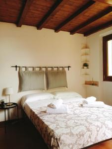 Small Heaven in Florentine hills في فلورنسا: غرفة نوم بسرير كبير عليها منشفتين