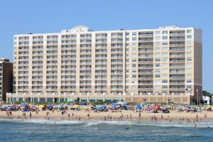 un gran edificio en una playa con multitud de personas en SpringHill Suites by Marriott Virginia Beach Oceanfront en Virginia Beach