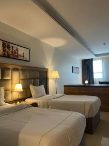 Habitación de hotel con 2 camas y ventana en بياسة للاجنحة الفندقية en Riad